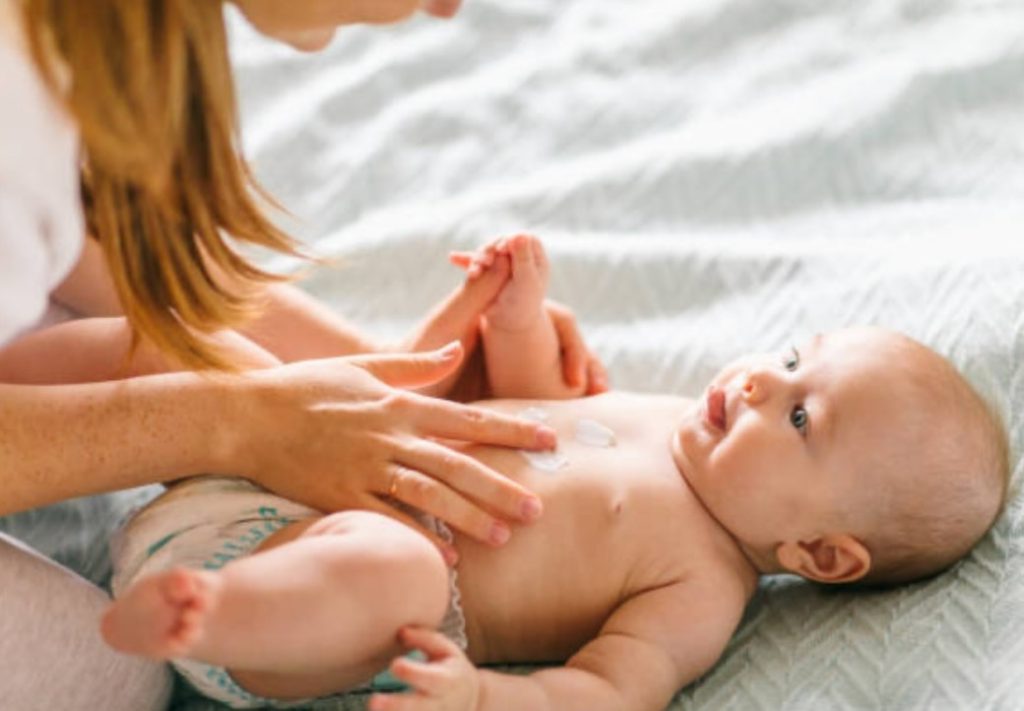 Parent applying moisturizer moisturizer to baby’s skin