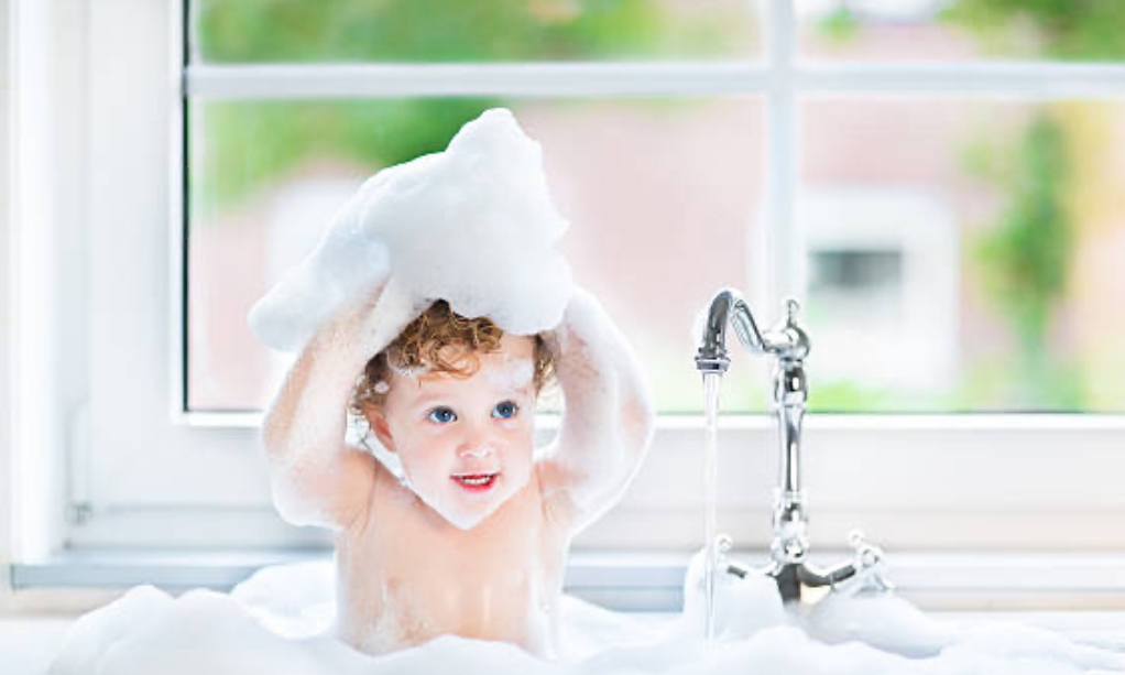 Kid enjoying 2-in-1 shampoo and body wash.